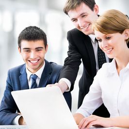 Young business workers gathered around a laptop